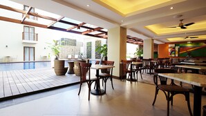 A spacious indoor area with a pool, dining tables, and chairs. - Altabriza Resort Boracay (Boracay Island)