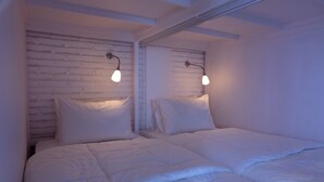 A bedroom with two beds, white bedding, and wall-mounted light fixtures. - Sweet Peach House (Senggigi)