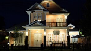 A two-story house with a balcony, a front porch, and a sign above the door. - Sweet Peach House (Senggigi)