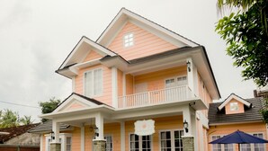 A two-story house with a balcony, a porch, and a sign that reads "Sweetpatch." - Sweet Peach House (Senggigi)