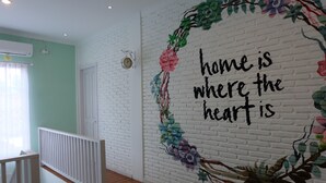 A room with a white brick wall, a white door, and a white railing. - Sweet Peach House (Senggigi)