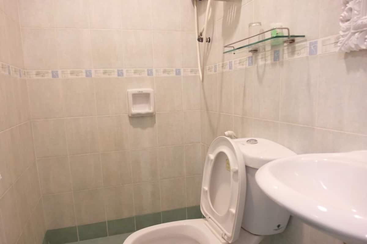 A bathroom with a toilet, a sink, and a shower.