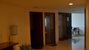 A room with a tiled floor, a water dispenser, and a door leading to another room. - Li Garden Hotel (Pasir Gudang)
