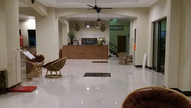 A spacious lobby with a reception desk, wicker furniture, and a ceiling fan. - Blue Diamond Guest House - Hostel (Battambang)