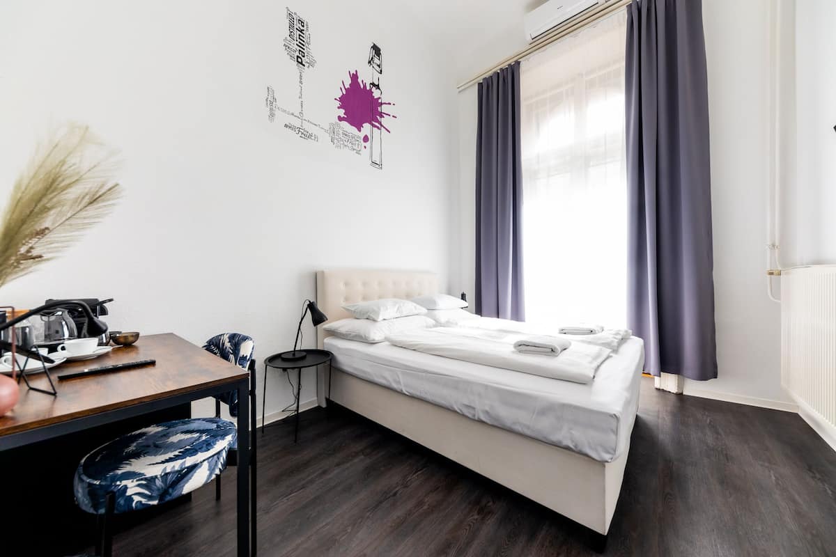 A modern bedroom with a bed, a desk, and a chair.