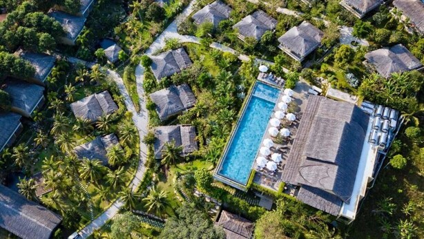 An aerial view of a resort with thatched-roof villas, a central swimming pool, and lush greenery. - Lahana Resort Phu Quoc & Spa (Phu Quoc)