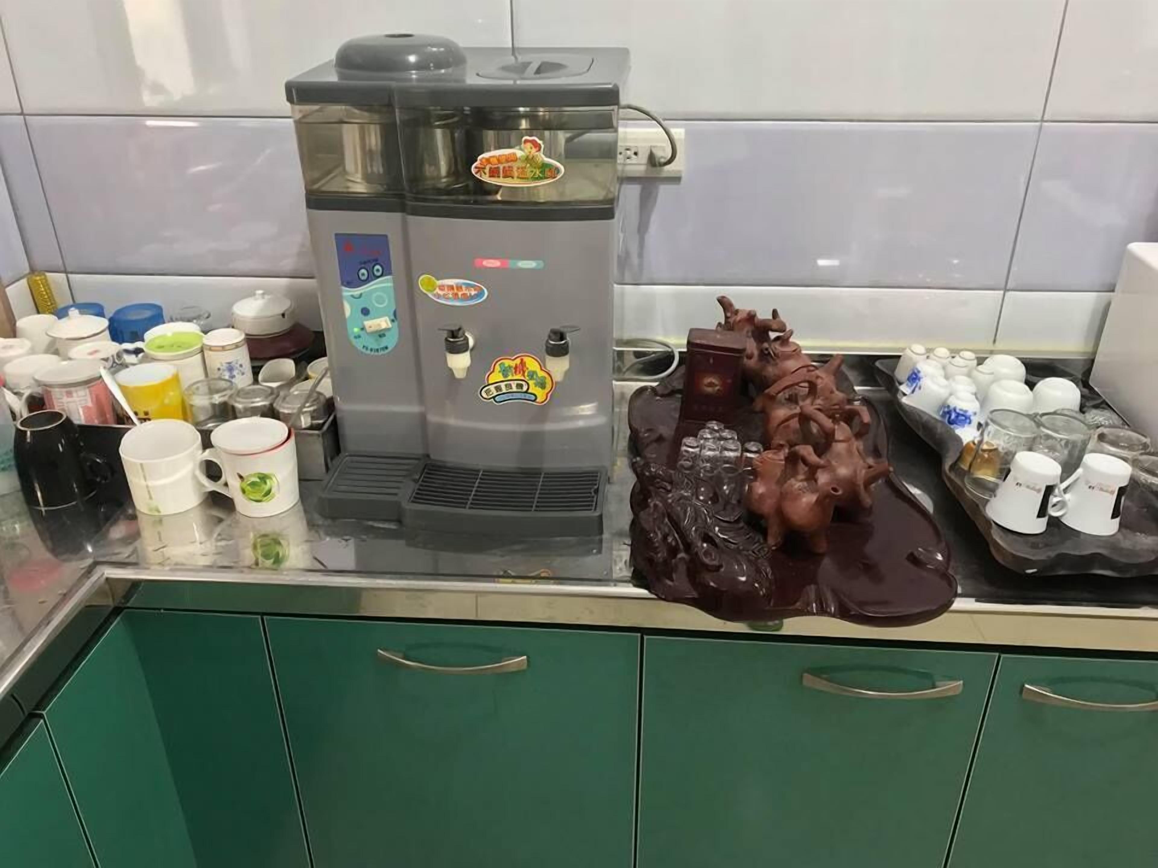 A coffee machine with multiple dispensers and a decorative pig sculpture on a counter.