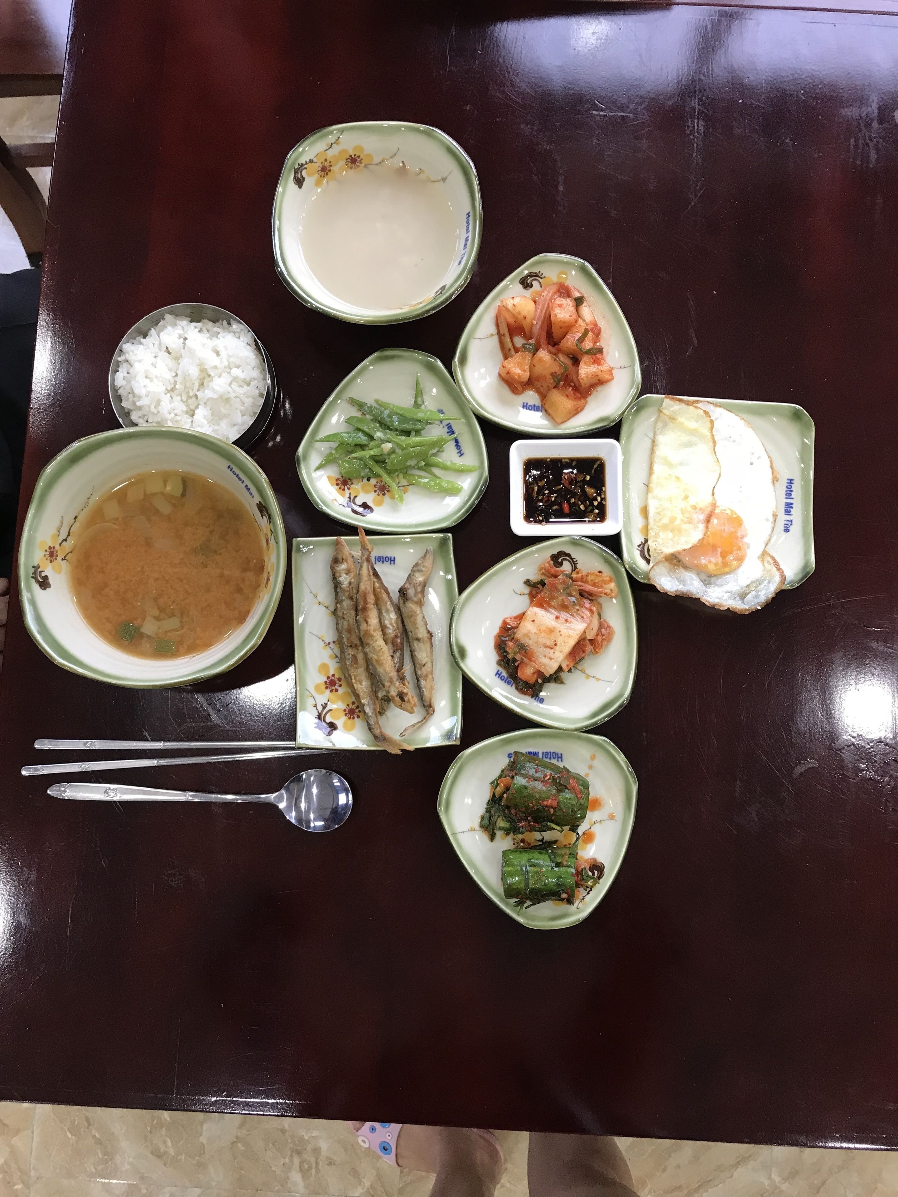Une table où l’on trouve divers plats, notamment du riz, de la soupe, du kimchi et d’autres spécialités de la cuisine coréenne.