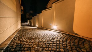 A cobblestone alleyway with buildings on either side, illuminated by warm lighting. - Hotel Sundial (Zagreb)