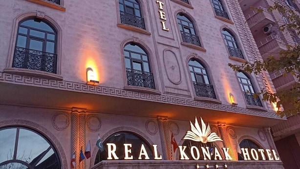 Exterior de l'Hotel Real Konak, amb arquitectura clàssica i senyalització il·luminada.