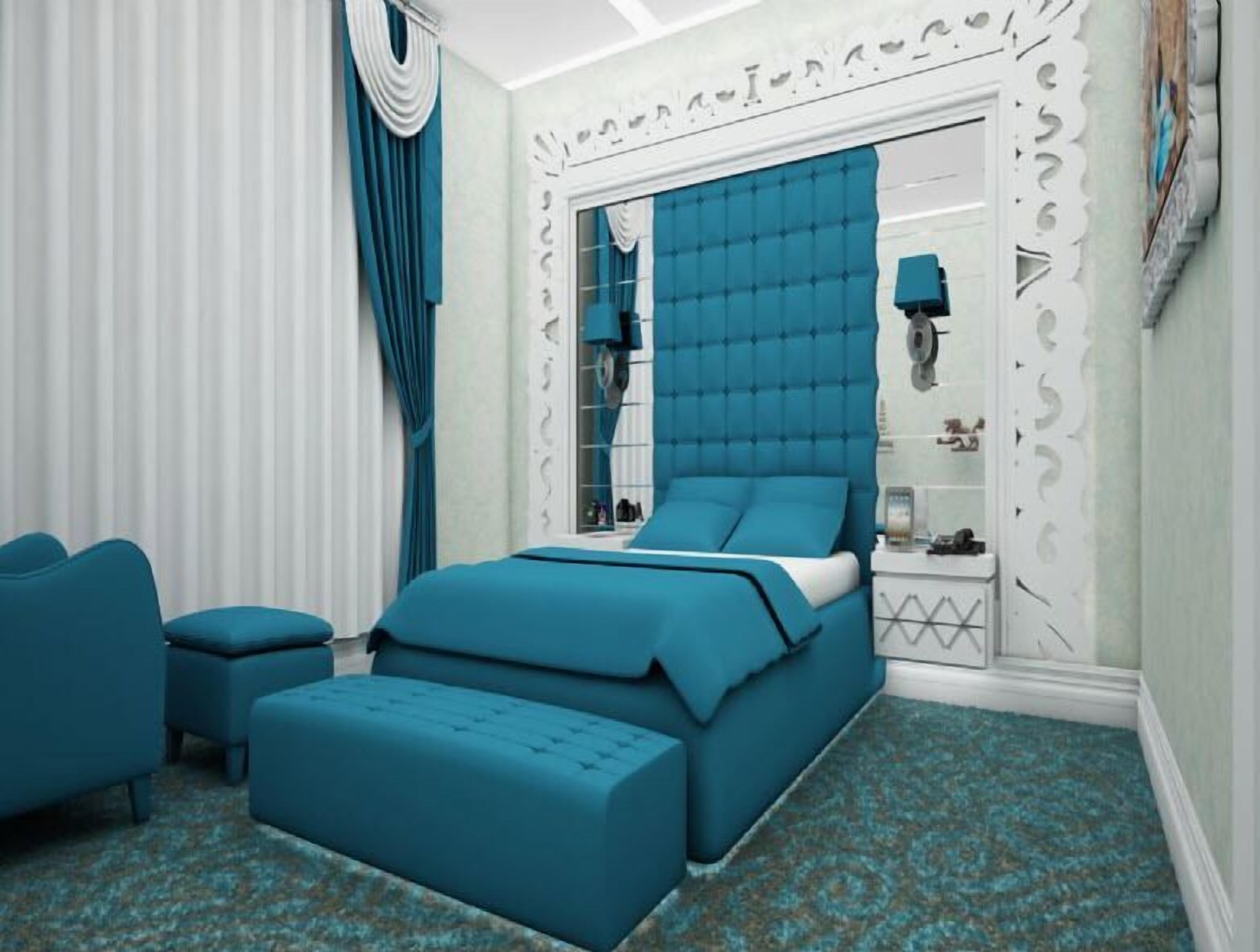 A bedroom with a bed, a chair, and a nightstand.