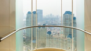 A high-rise building with a view of a cityscape through a glass railing. - Hoasun Boutique Apartment - Vinhomes Central Park (Ho Chi Minh City)