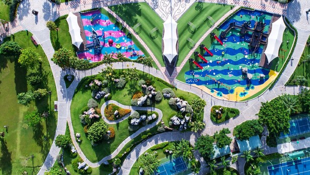 An aerial view of a park with multiple playgrounds, walking paths, and green spaces. - Hoasun Boutique Apartment - Vinhomes Central Park (Ho Chi Minh City)