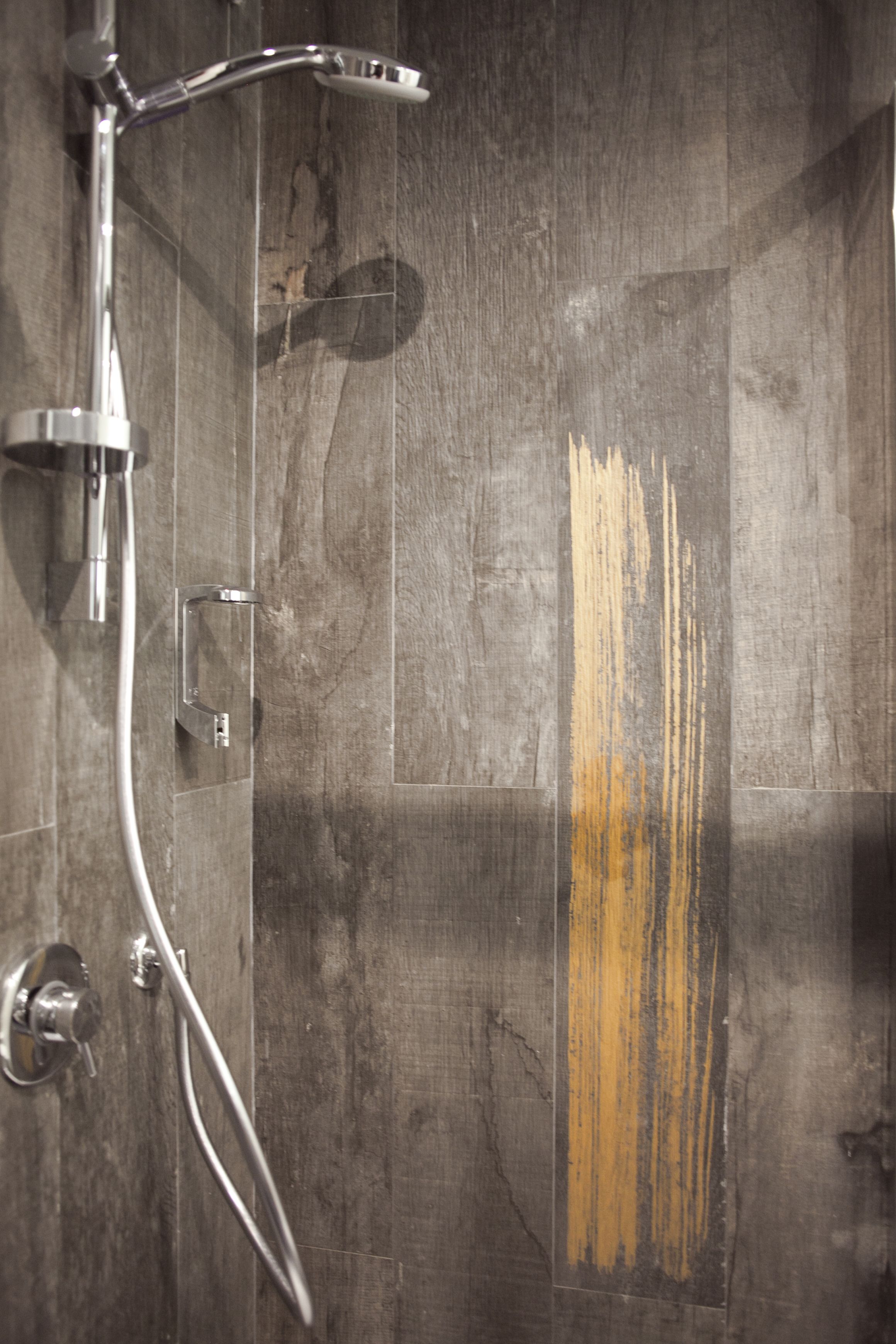 A shower area with a chrome showerhead and a handheld shower attachment.