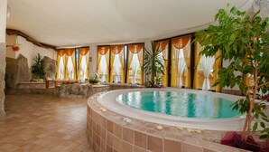 A spa area with a hot tub, tiled floor, and large windows with curtains. - Hotel Val di Sole (Mezzana)