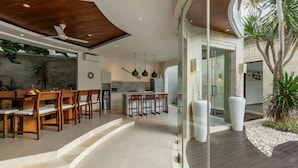A modern kitchen with a central island, wooden dining table, and chairs.