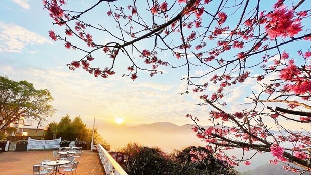 A terrace with tables and chairs, overlooking a mountainous landscape with a sunset. - Alishan Tea Garden (Fanlu)