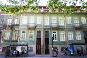 A historic building with multiple balconies, a central entrance, and a covered waiting area. - Liiiving in Porto - Central Garden Flat (Porto)