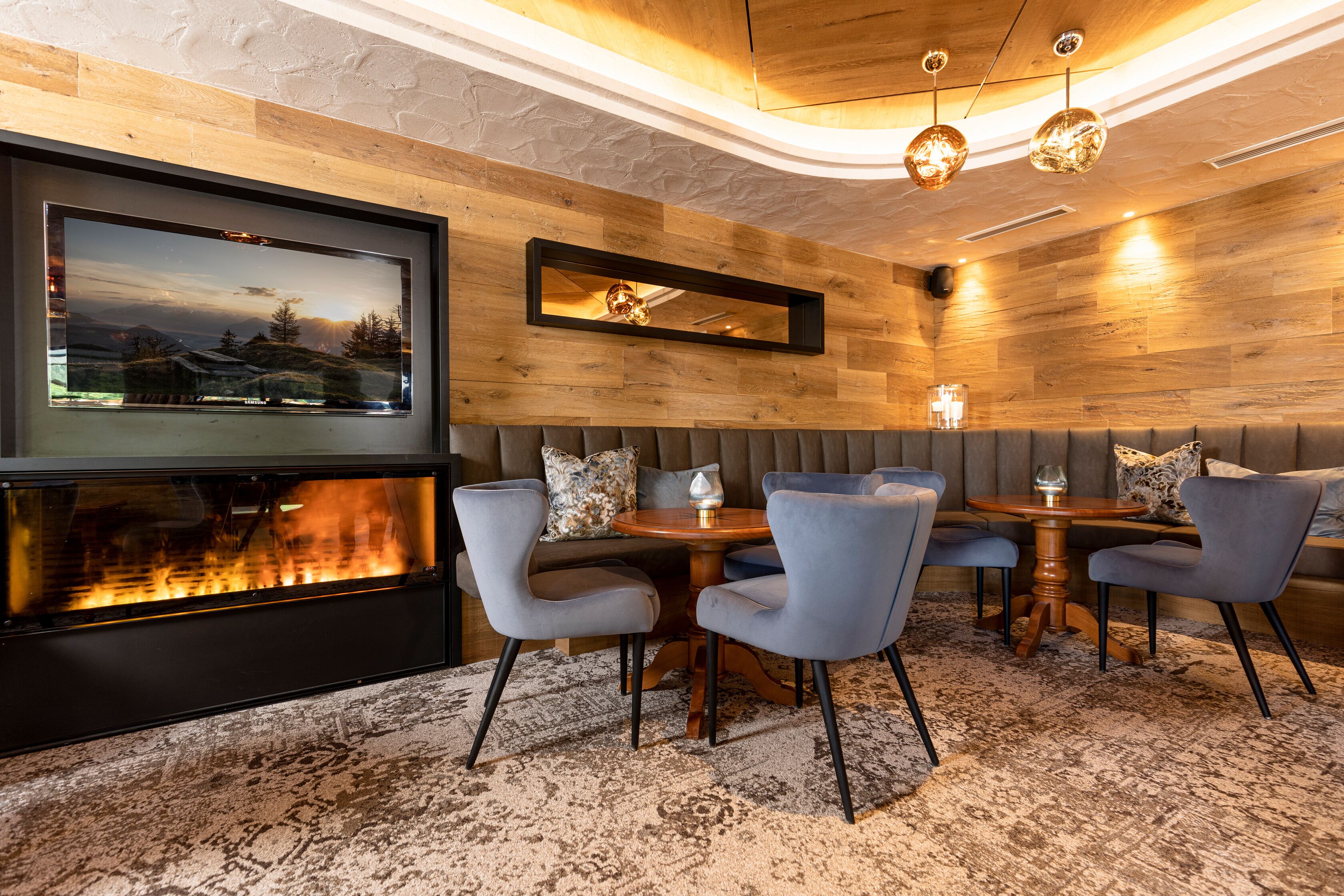 Un interior moderno con chimenea, zona de estar y paredes de madera.