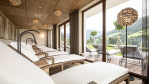 Un cuarto de spa con sillones reclinables, ventanas amplias y vistas al exterior.