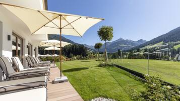 A terrace with outdoor seating and a view of mountains.