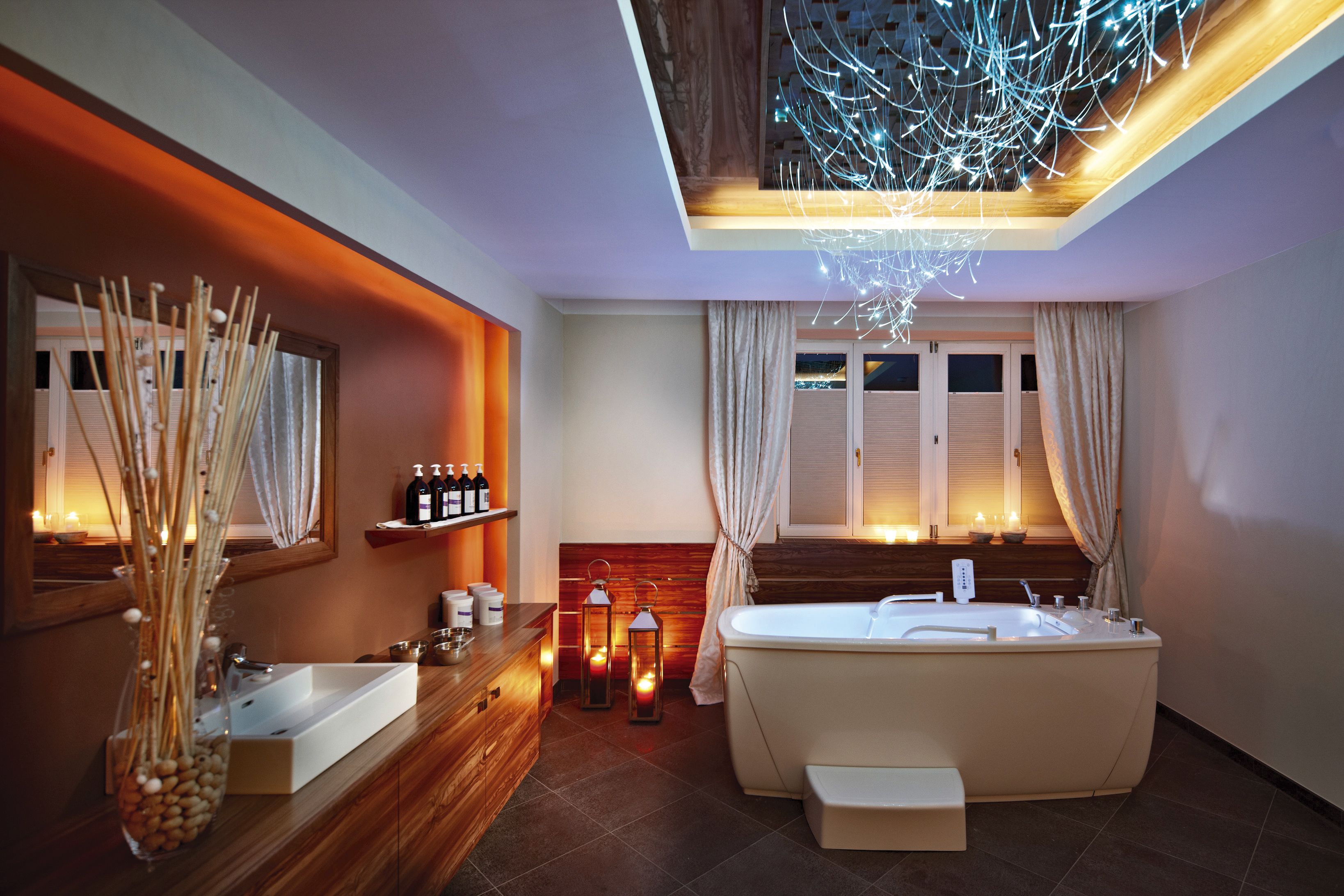 A modern bathroom with a freestanding bathtub, a vanity with a mirror, and a decorative vase with sticks.