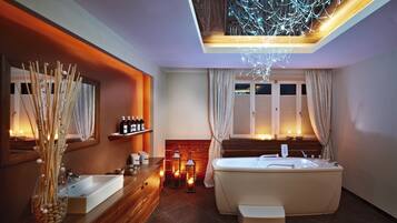 A modern bathroom with a freestanding bathtub, a vanity with a mirror, and a decorative vase with sticks.
