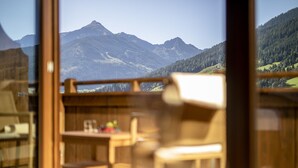 Una habitación con vista a montañas, una mesa de madera y una silla.