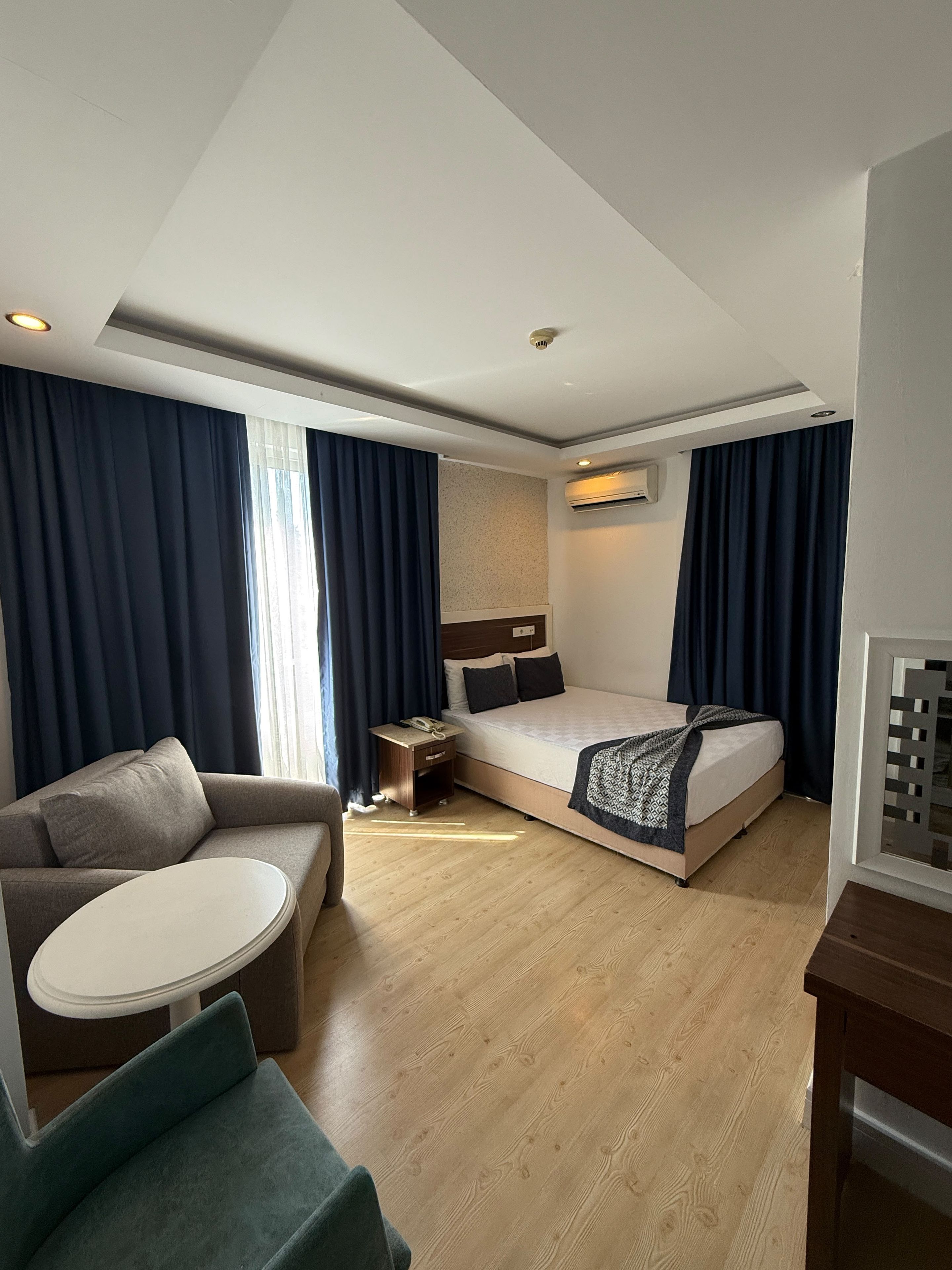Ein Hotelzimmer mit einem Bett, einer Couch, einem kleinen Tisch und einem Schreibtisch.