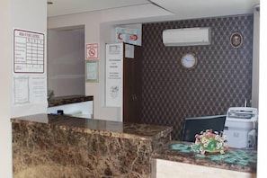 A reception area with a marble counter, a clock, and a wall-mounted air conditioner. - River Boutique Hotel (Manavgat)