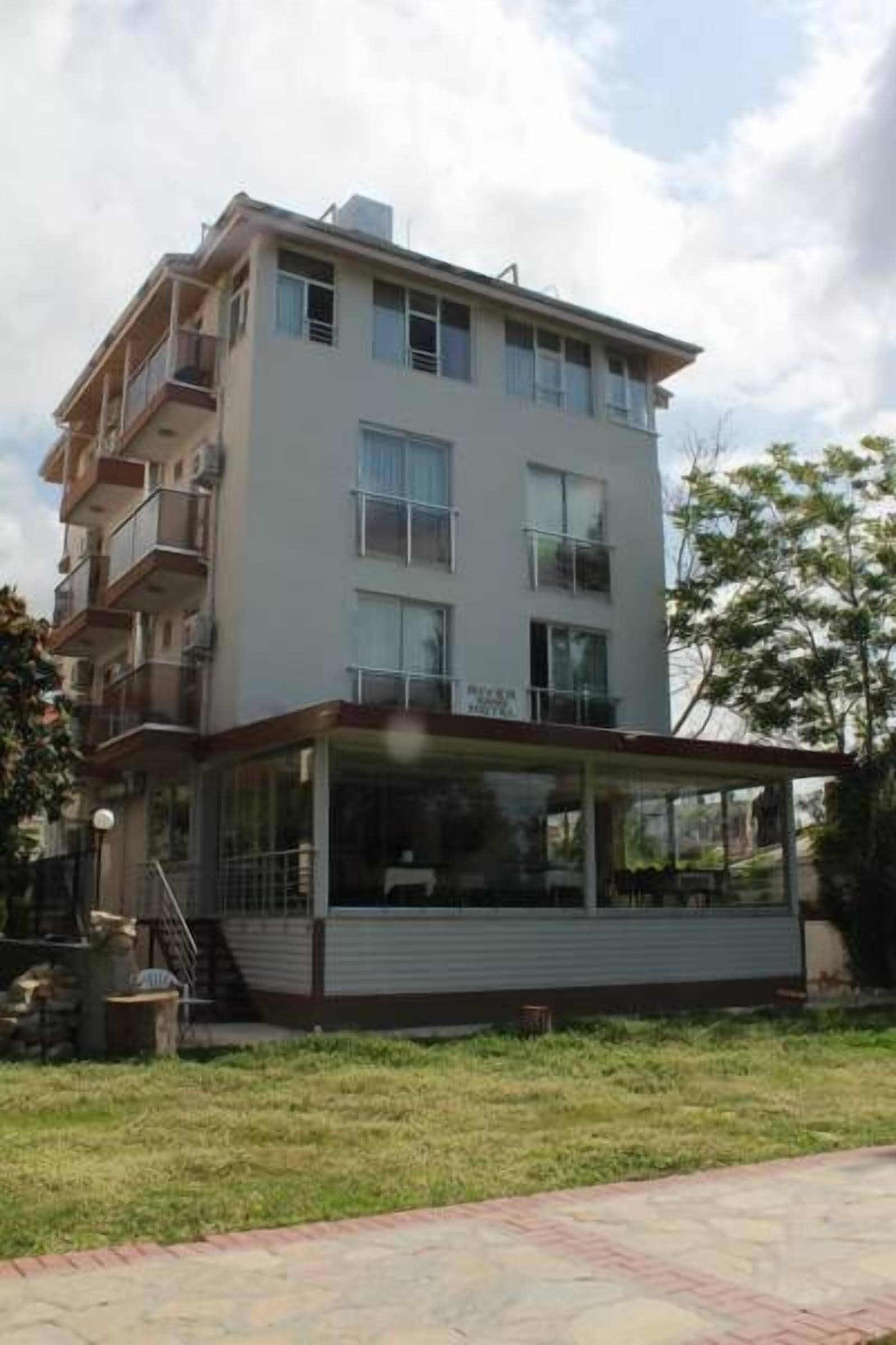 A multi-story residential building with balconies, a covered outdoor area, and a visible staircase.