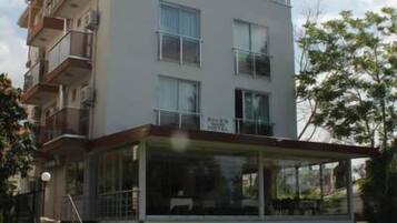 A multi-story residential building with balconies, a covered outdoor area, and a visible staircase.