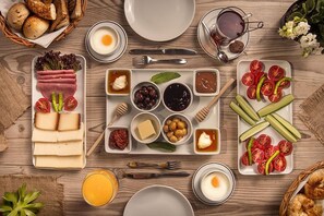 A breakfast setting with various food items and utensils on a wooden table. - River Boutique Hotel (Manavgat)