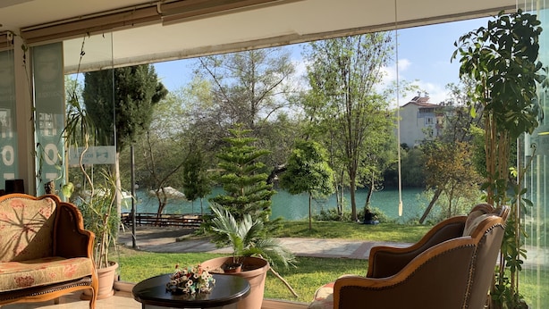 Una habitación moderna con un ventanal grande, un sofá, una mesa de centro y una silla.