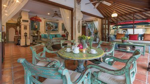 A spacious room with a round table, chairs, and a ceiling fan. - Villa Kaja by Nagisa Bali (Seminyak)