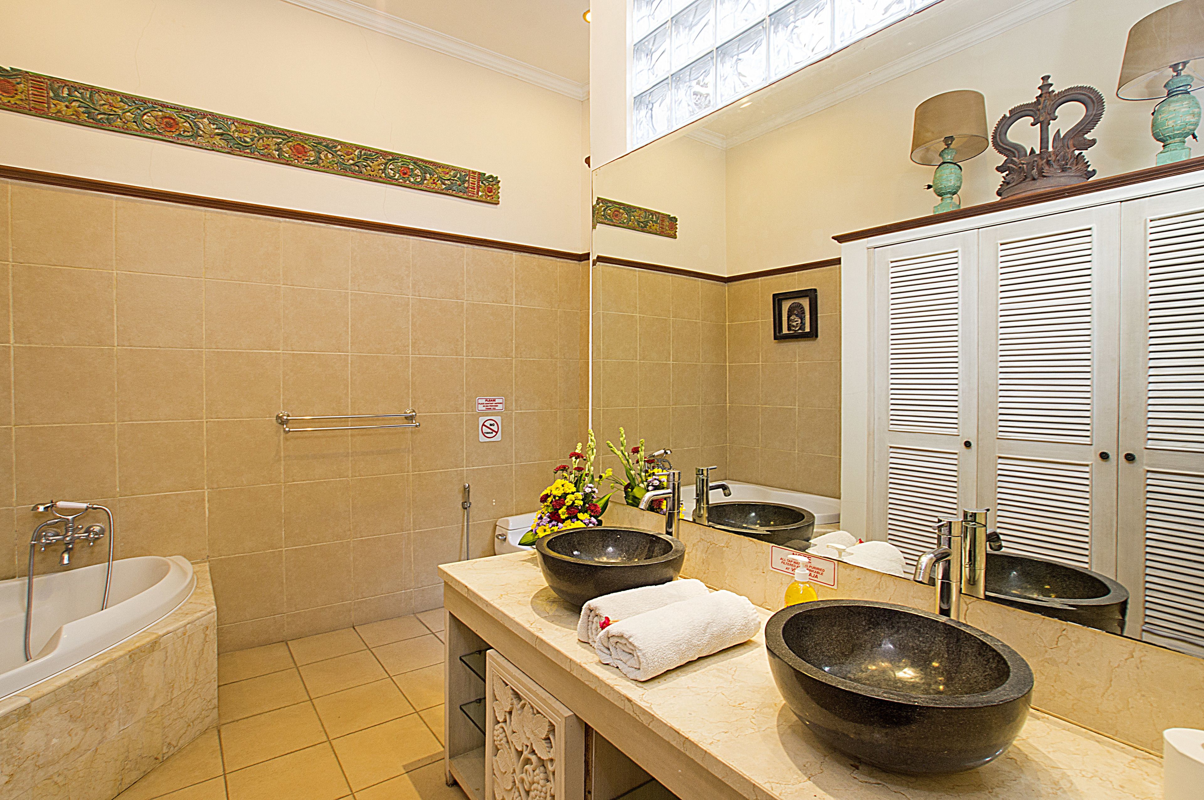 A bathroom with two sinks, a bathtub, and a shower.