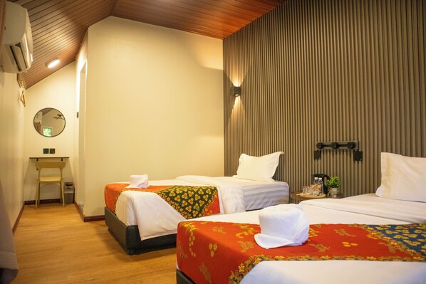 Habitación de hotel con dos camas, un escritorio y un espejo.