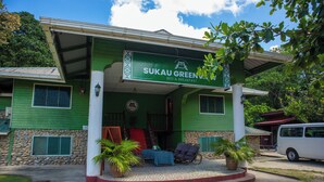 Un bâtiment à la façade verdoyante, sur lequel on peut lire l’inscription « SUKAU GREEN BED & BREAKFAST  ».