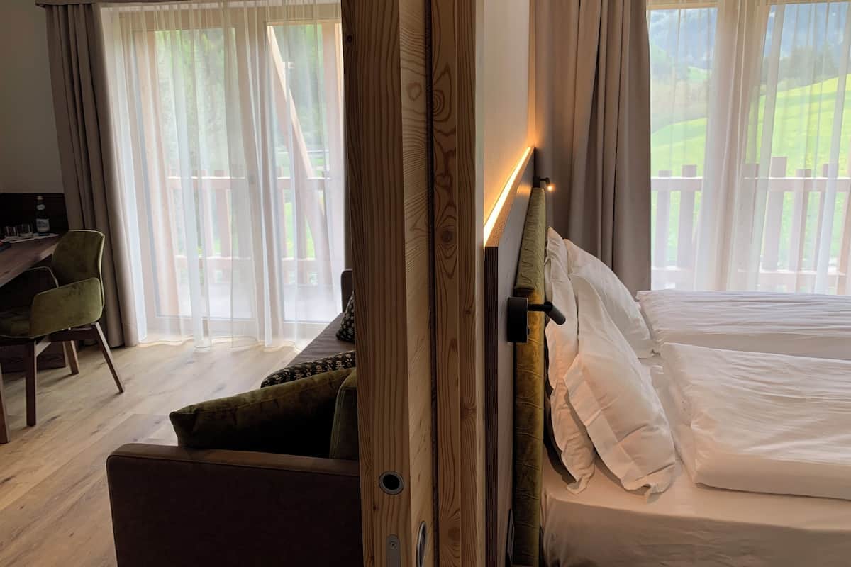 A hotel room with a bed, a desk, and a chair.
