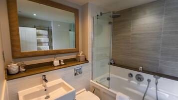 A modern bathroom with a glass-enclosed shower, a white sink, and a large mirror.