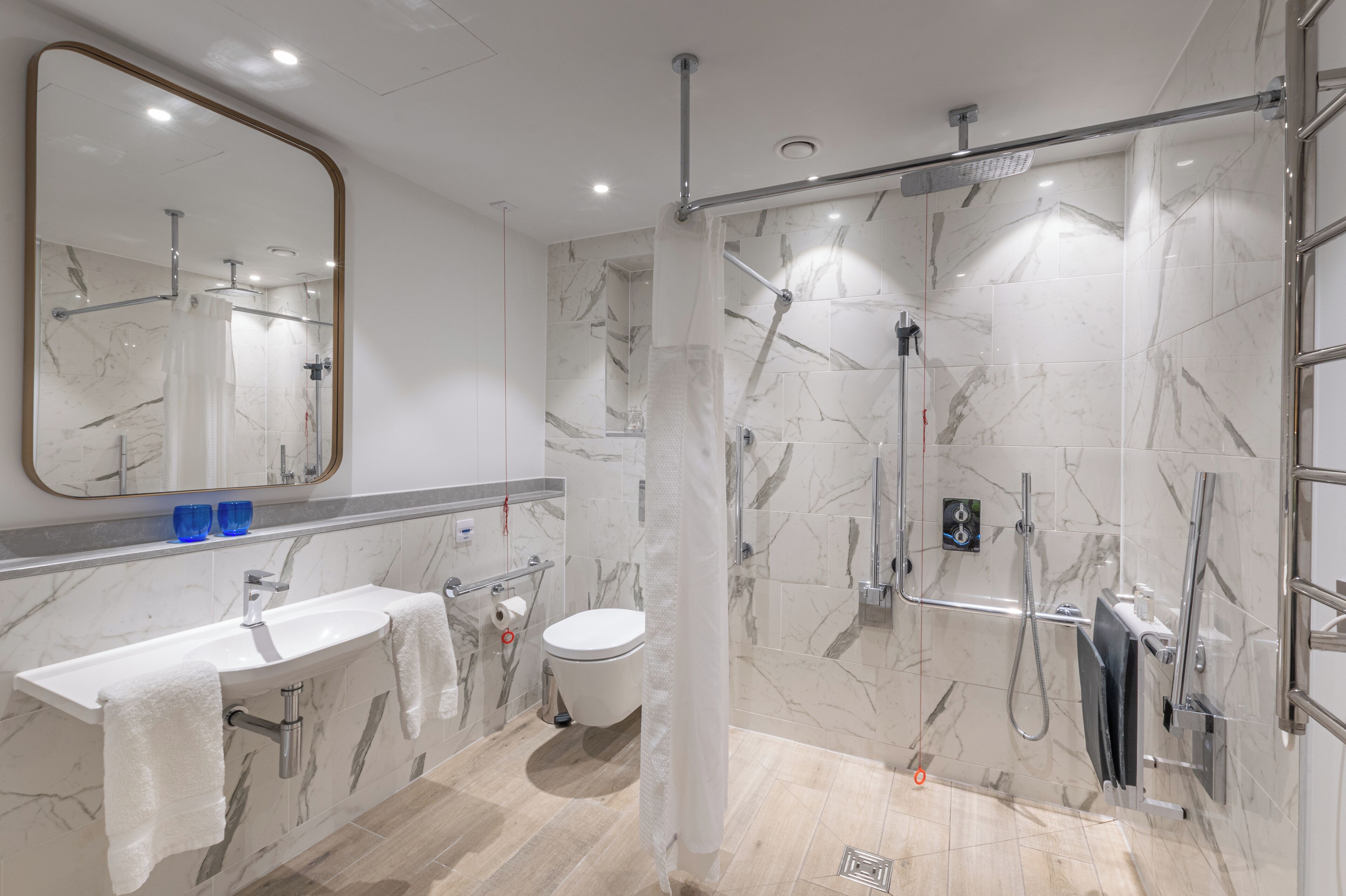 Une salle de bain moderne avec un lavabo, des toilettes et une douche, le tout en marbre.