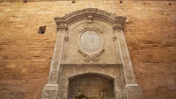 Una pared de piedra con una inscripción tallada y un arco decorativo.