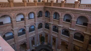 A multi-level atrium with brick architecture, multiple balconies, and a central seating area.