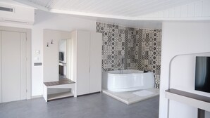 Un baño moderno con una bañera grande, zona de ducha y tocador con espejo.