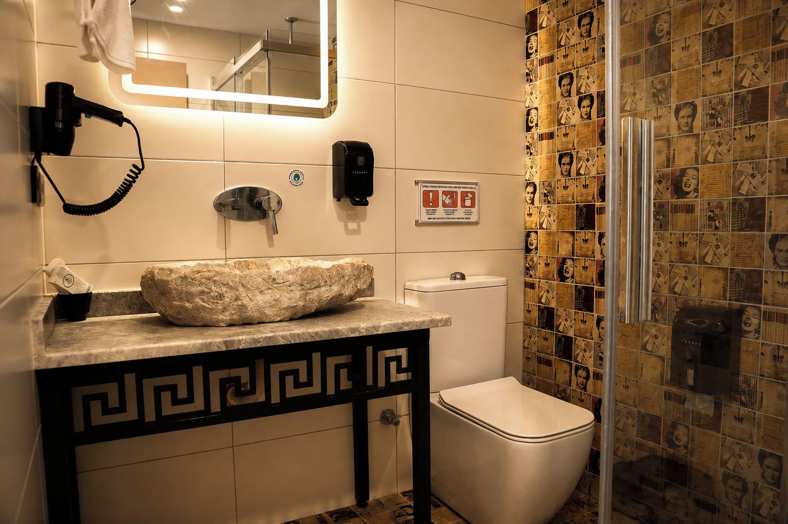 Een badkamer met een marmeren wastafel, een haardroger, een handdoekrek, een toilet en een douchegedeelte.