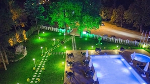 Un espacio al aire libre con piscina, asientos y un camino.