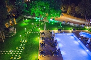 Un espacio al aire libre con piscina, asientos y un camino.
