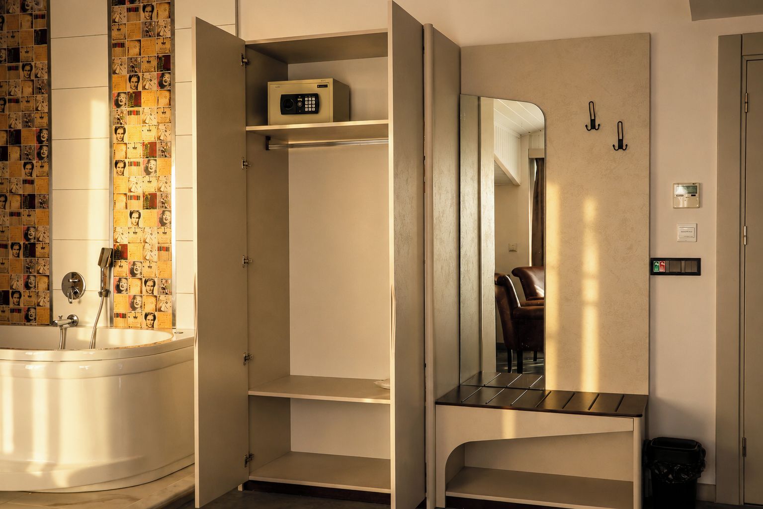 Een badkamer met een bad, een spiegel en een plank met een apparaat.