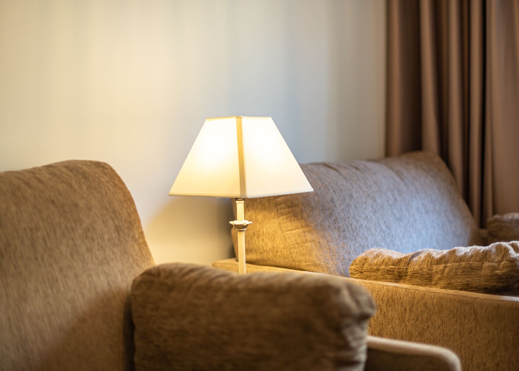Una habitació amb un sofà i una làmpada de taula.