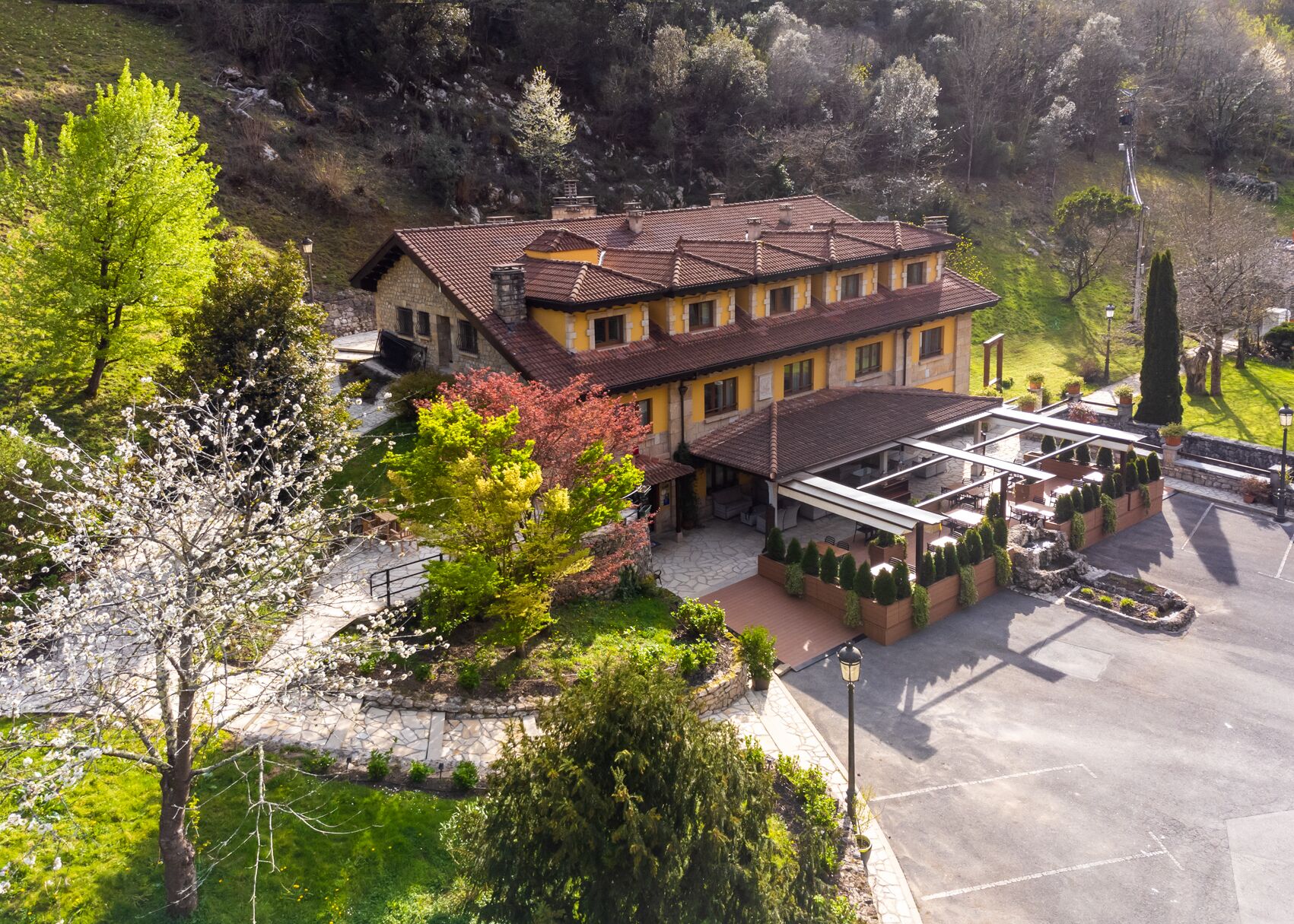 Un edificio de dos pisos con patio, camino de piedra y zona de estar al aire libre.
